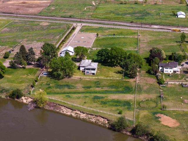 Discover equestrian bliss on this 5.3-acre waterfront estate along the North Thompson River, just 20 minutes from downtown Kamloops. Ideal for horse lovers, it features a 36 x 36 barn with five 12 x 12 stalls, automatic waterers, and a heated tack room. The property includes four pastures with electric fencing, two outdoor paddocks, and an 80 x 200 arena. The 3400 sqft ranch home offers two bedrooms on the main floor, including a master suite with a 3-piece ensuite and panoramic river and foothill views from the expansive living and dining areas. The basement includes a third bedroom and bathroom with potential for additional rooms. Modern amenities include 200 amp service, an oversized garage, and a woodstove. Enjoy the scenic riverfront from your walkout deck, combining serene country living with city convenience. This property is a perfect blend for a family home with vast outdoor potential in a vibrant community.