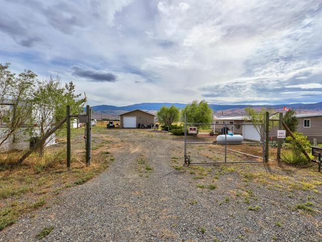 Discover your own private retreat just 35 minutes west of Kamloops on this serene 4.85-acre property in the Thompson River Valley. The 1,200 sq. ft. renovated home offers modern comfort with an open-concept kitchen, two bedrooms, a den, and a cozy living room featuring a charming wood stove. The attached 17x24 garage and a 28x32 detached, fully wired workshop with high ceilings provide ample space for projects and hobbies. Enjoy the lush gardens, trees, and partially fenced grounds with a deep well and 18,000-liter cistern. Wildlife enthusiasts will appreciate the bighorn sheep and other creatures that roam the nearby hills. A guest suite with a kitchen and bathroom is perfect for entertaining. Embrace the peace and quiet of country living with all the space you need in this idyllic setting.