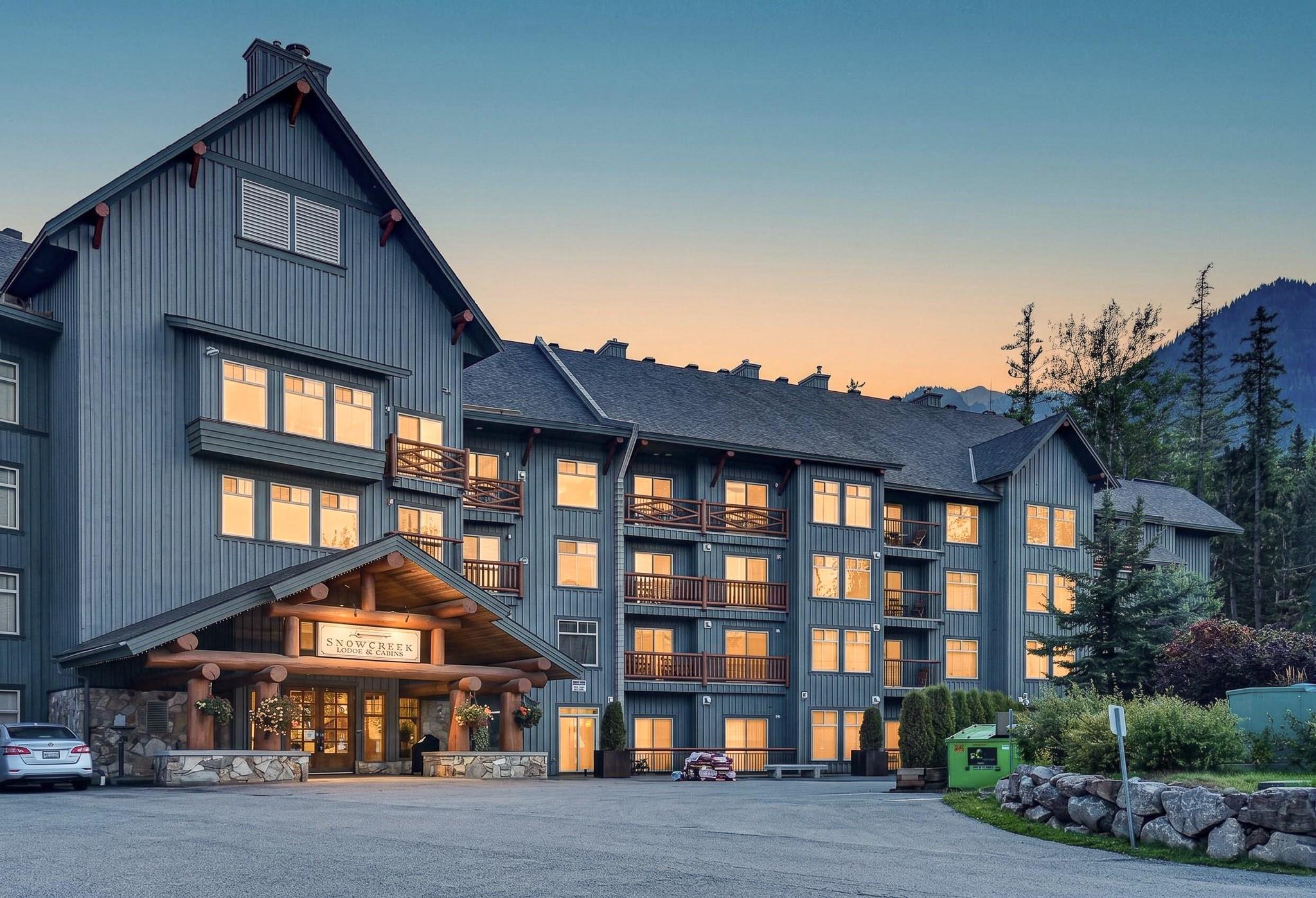 Snow Creek Lodge at dusk with the mountains beyond